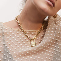 Gold plated link chain necklace with heart shaped lock and evil